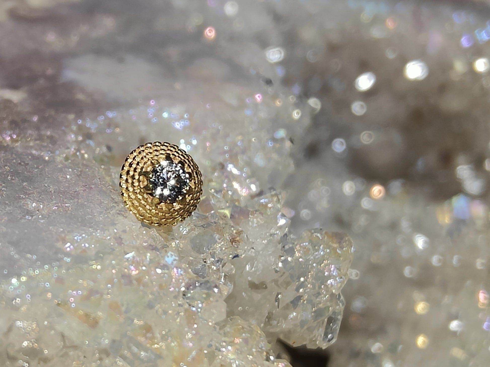 cricular solid gold milligrain end with a small white gem in the centre