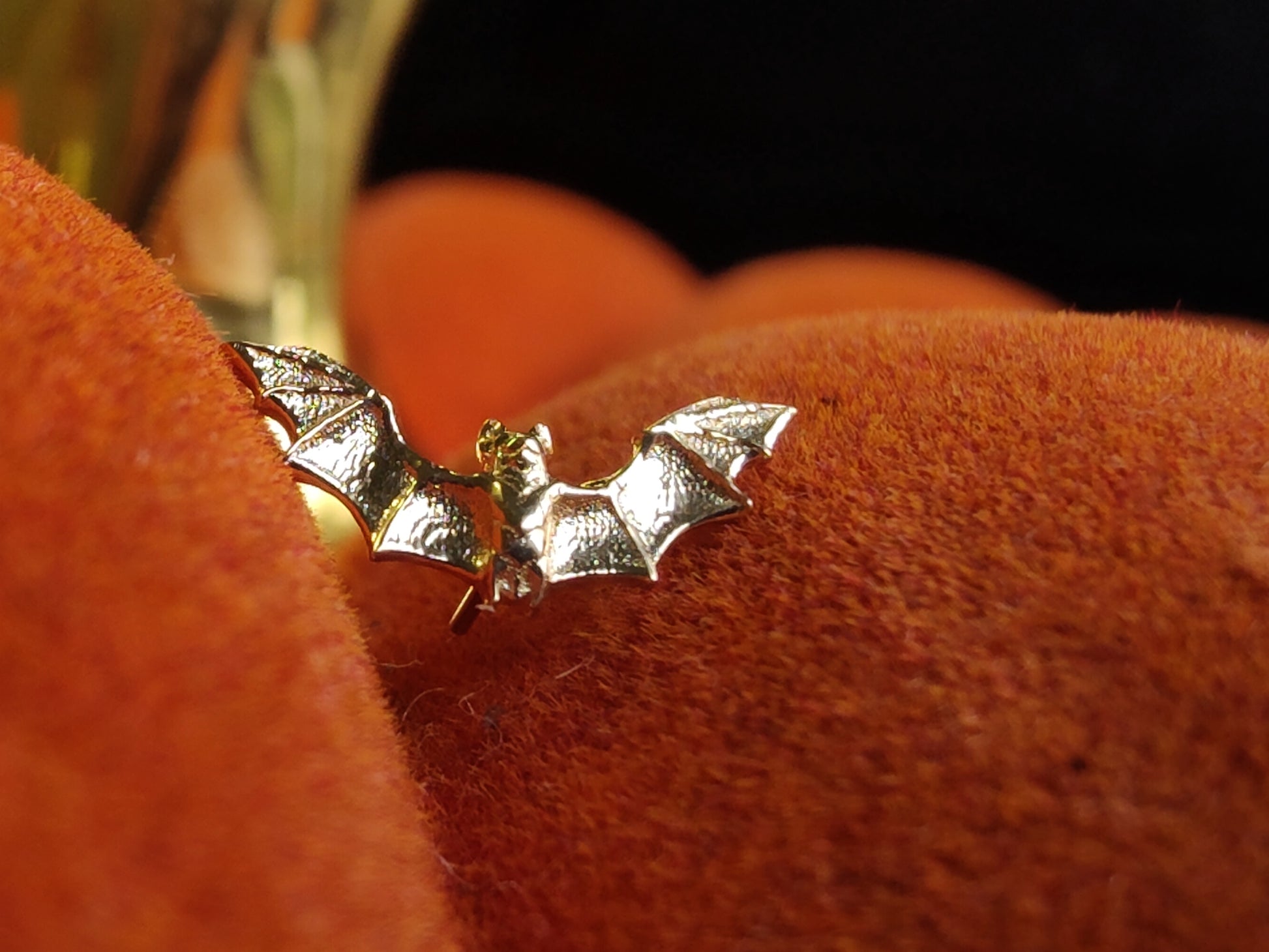 solid gold end in the shape of a bat on a decorative pumpkin