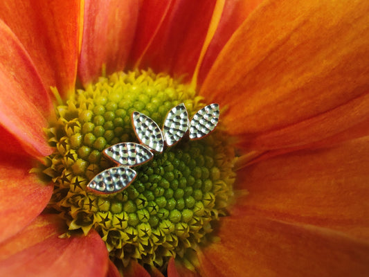 5 marquise cut solid gold hammered shaped connected in a fan shape sat on a burnt orange flower