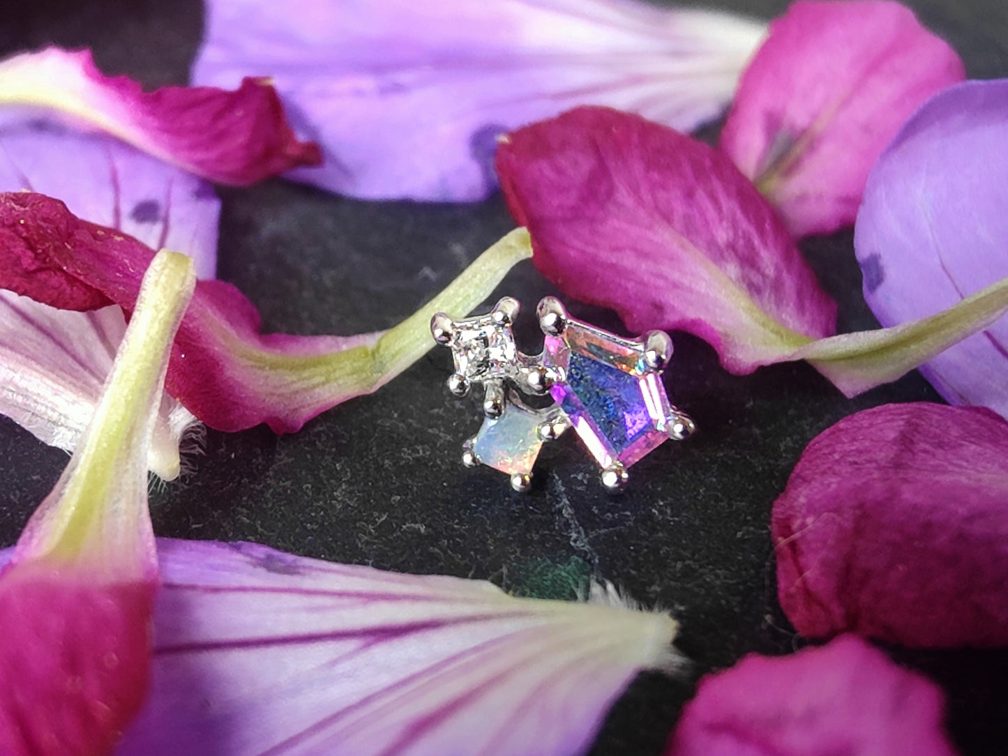 3 stones of different sizes connected by a gold setting. one in mercury mist topaz, one opal and one white cz.