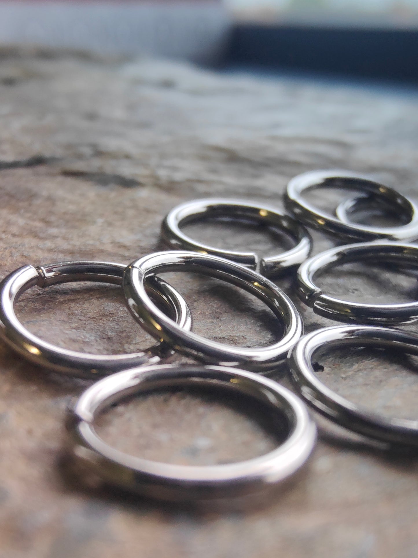 a pile of 7 niobium seam rings on a piece of slate