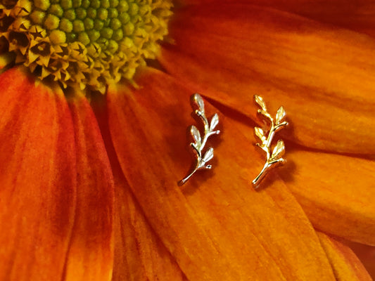 2 attchements in the shape of a leaf in yellow gold and white gold set on a burnt orange leaf