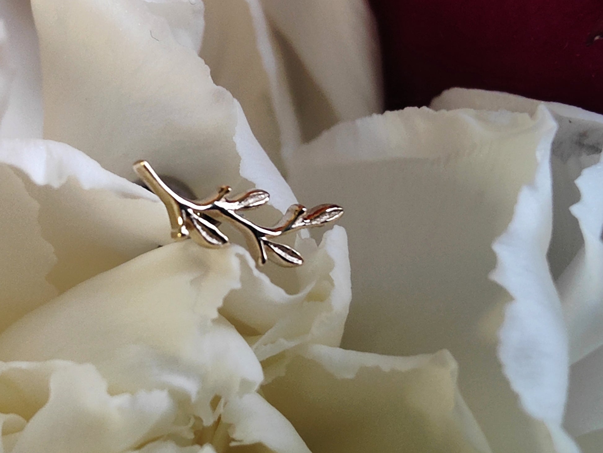 an attchement in the shape of a leaf in yellow gold set on white flower