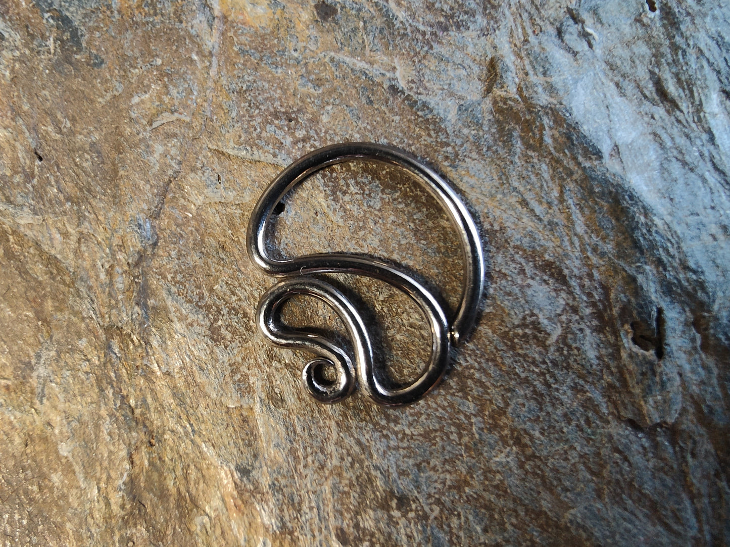 a niobium seam ring with a curly design