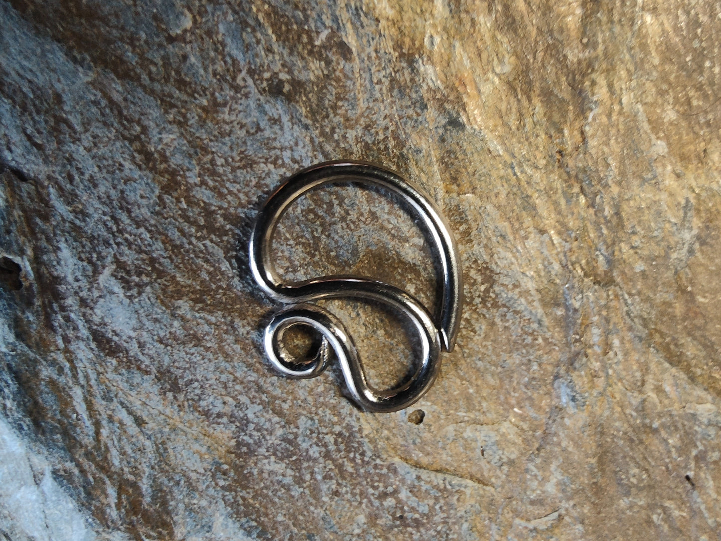 a niobium seam ring with a curly design